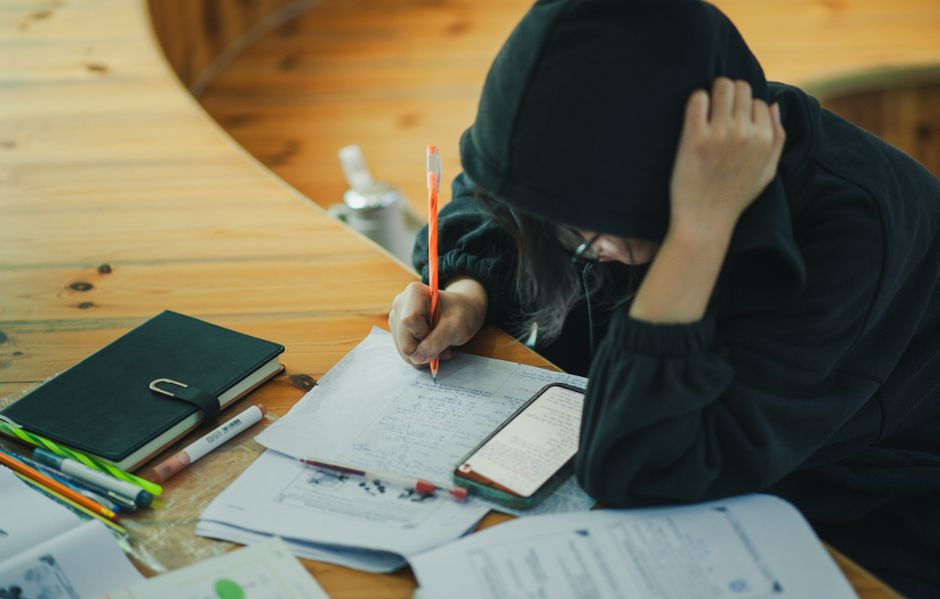 Estudiante escribiendo notas en un cuaderno