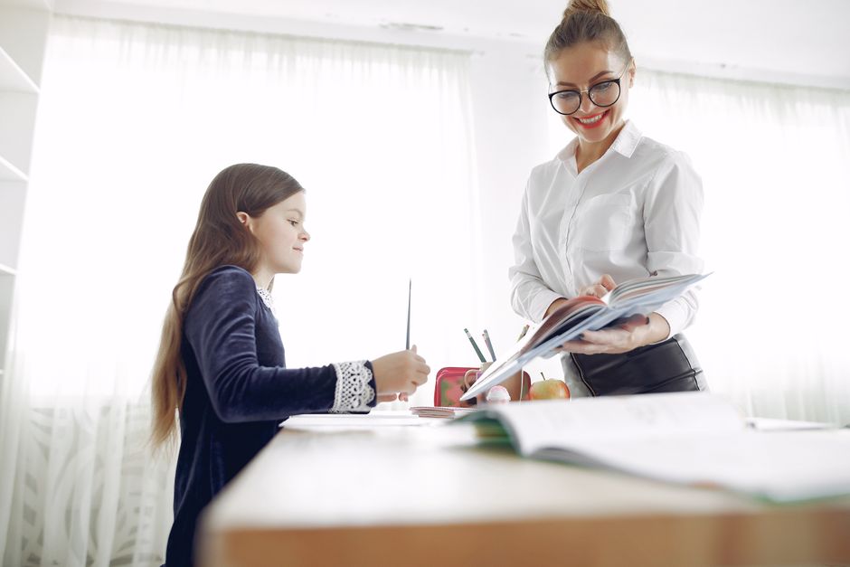 Profesora dando retroalimentación uno a uno a una alumna